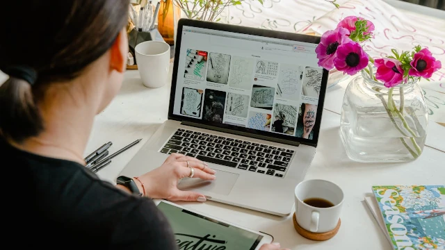 Woman using a laptop for graphic design at a desk