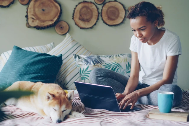 Woman works on laptop with her dog